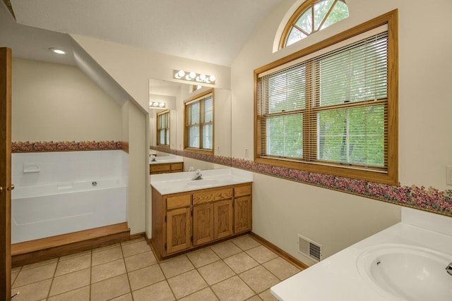 4906 Bayswater Rd, Minnetonka, MN 55345 - bathroom featuring two vanities, vaulted ceiling, tile patterned floors, a garden tub, and baseboards