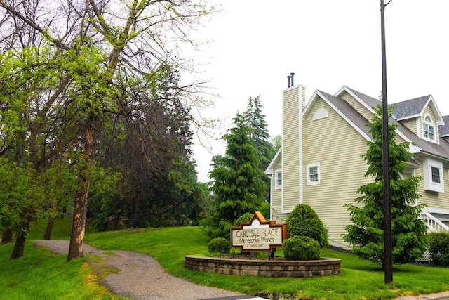 4906 Bayswater Rd, Minnetonka, MN 55345 - view of side of home featuring a yard, a chimney, and roof with shingles