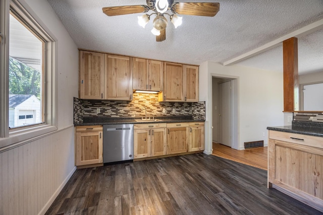 1605 4th St SW, Austin, MN 55912 - kitchen featuring stainless steel dishwasher, a textured ceiling, a sink, backsplash, and dark countertops