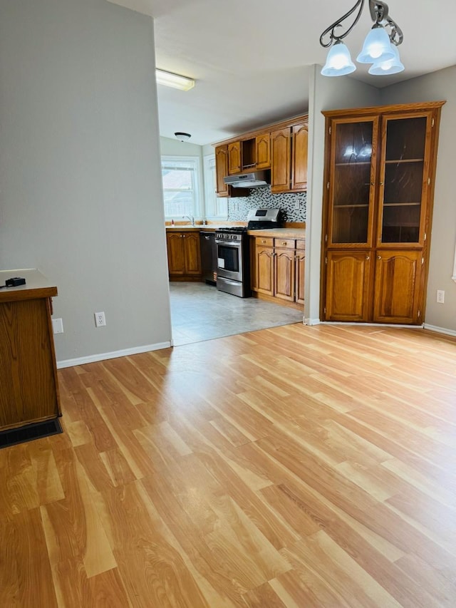 98 Magnolia Ave W, Saint Paul, MN 55117 - kitchen with stainless steel range with gas stovetop, under cabinet range hood, brown cabinets, light wood-style flooring, and dishwasher