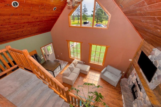 4985 Sam Anderson Rd, Amnicon Twp, WI 54874 - living area featuring a stone fireplace, wooden ceiling, high vaulted ceiling, and wood finished floors