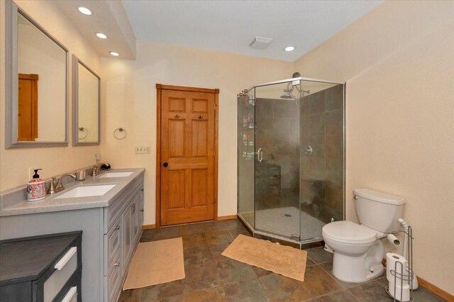 4985 Sam Anderson Rd, Amnicon Twp, WI 54874 - bathroom with a shower stall, toilet, double vanity, baseboards, and recessed lighting
