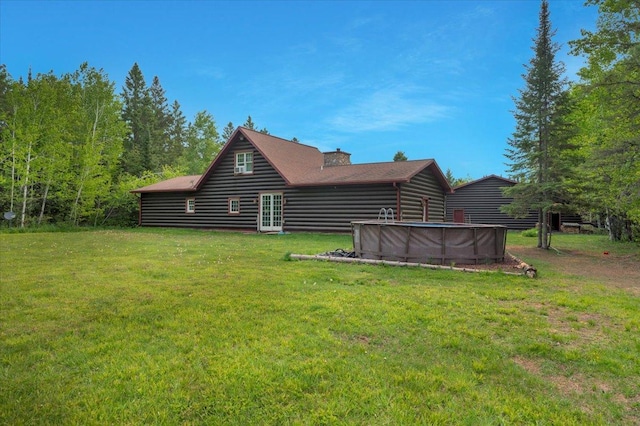 4985 Sam Anderson Rd, Amnicon Twp, WI 54874 - back of house featuring a yard, an outdoor pool, french doors, and a chimney
