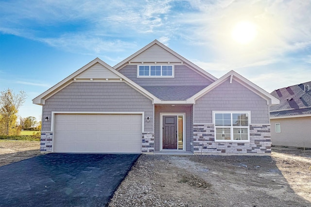 7807 Bridgewater Ct, Greenfield, MN 55373 - view of front of home featuring stone siding, asphalt driveway, and a garage
