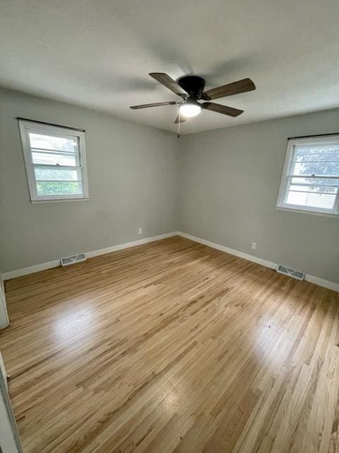 4155 7th St, Goodview, MN 55987 - empty room with plenty of natural light, light wood-style floors, ceiling fan, and baseboards