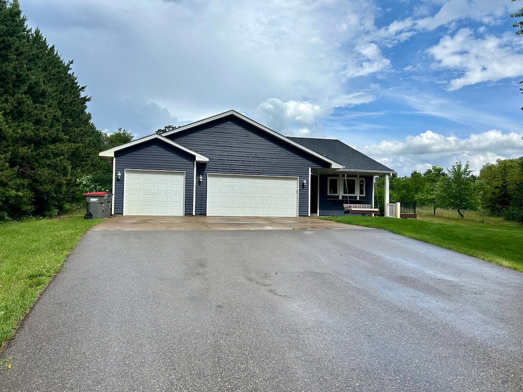 22225 Washington St NE, East Bethel, MN 55011 - ranch-style home featuring asphalt driveway, an attached garage, covered porch, and a front lawn