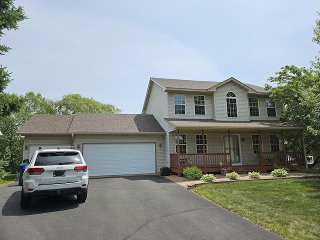 19389 Seymour St NW, Elk River, MN 55330 - view of front of house with driveway, an attached garage, a front lawn, covered porch, and roof with shingles
