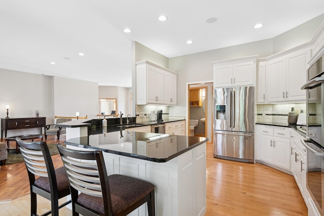 6654 Orchid Ln N, Maple Grove, MN 55311 - kitchen featuring stainless steel appliances, a kitchen breakfast bar, decorative backsplash, light wood-type flooring, and recessed lighting