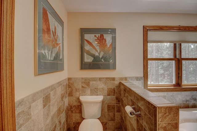 20929 Faron Dr, Nevis, MN 56467 - full bathroom featuring tile walls, toilet, a tub, and a wainscoted wall