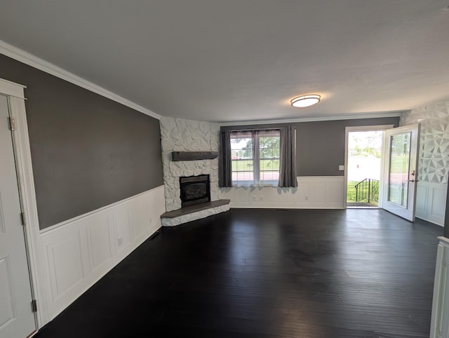 530 Cardinal St, Fairmont, MN 56031 - unfurnished living room with ornamental molding, a wainscoted wall, a stone fireplace, a decorative wall, and dark wood finished floors