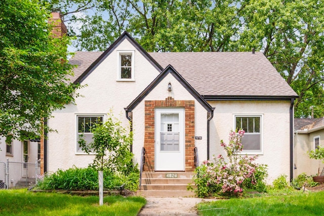 4826 33rd Ave S, Minneapolis, MN 55417 - tudor house featuring entry steps, a shingled roof, and stucco siding