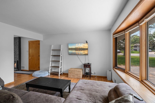 11411 Johnson Cir, Bloomington, MN 55437 - living room with light wood-style flooring, a brick fireplace, and baseboards