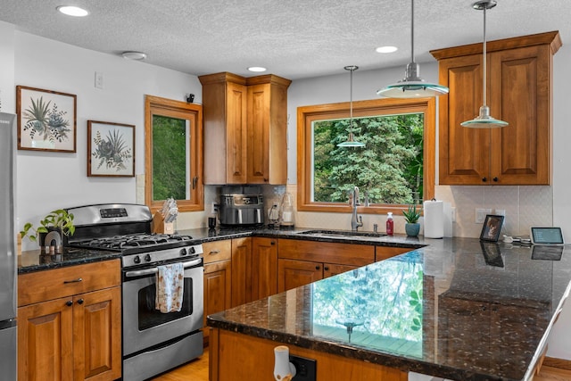 11411 Johnson Cir, Bloomington, MN 55437 - kitchen with appliances with stainless steel finishes, a sink, a peninsula, brown cabinets, and a textured ceiling