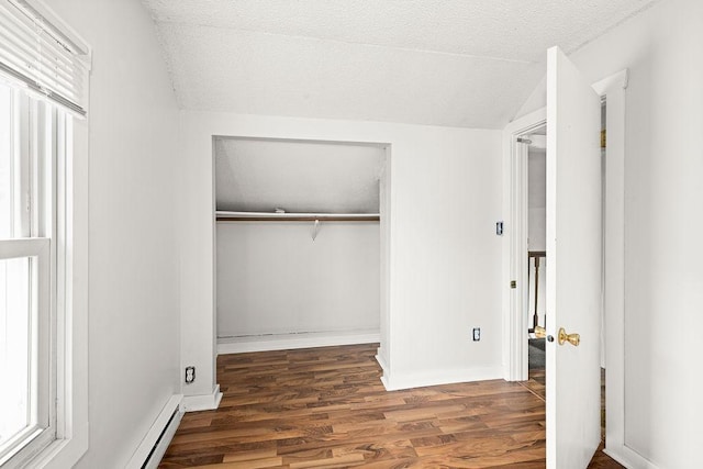 627 Skyline Pkwy, Duluth, MN 55805 - unfurnished bedroom featuring a closet, wood finished floors, a textured ceiling, vaulted ceiling, and baseboards