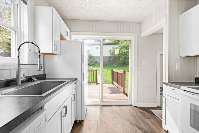 627 Skyline Pkwy, Duluth, MN 55805 - kitchen featuring a sink, white appliances, dark countertops, wood finished floors, and a textured ceiling