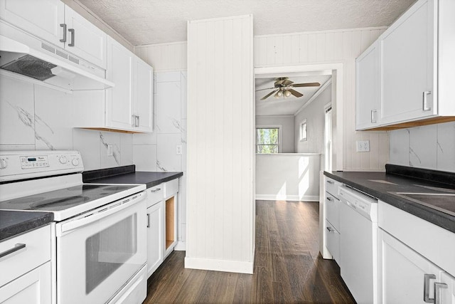 627 Skyline Pkwy, Duluth, MN 55805 - kitchen with white appliances, under cabinet range hood, dark wood-style flooring, dark countertops, and ornamental molding