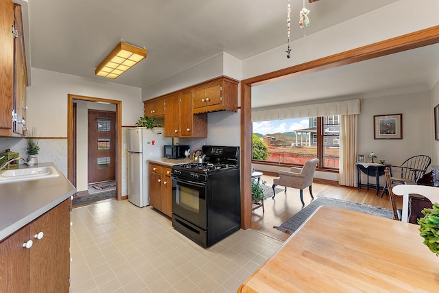 2142 Cottage Ave E, Saint Paul, MN 55119 - kitchen with black appliances, a sink, light countertops, and brown cabinetry