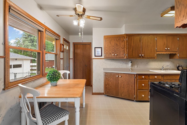 2142 Cottage Ave E, Saint Paul, MN 55119 - kitchen with a sink, brown cabinets, ceiling fan, black gas range oven, and light countertops