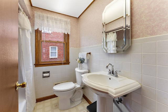 2142 Cottage Ave E, Saint Paul, MN 55119 - bathroom with toilet, a wainscoted wall, tile patterned floors, a shower with curtain, and tile walls