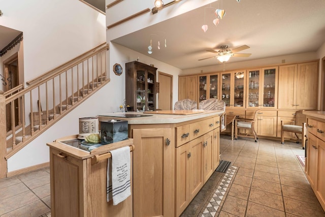 17159 Stalker Lake Rd, Battle Lake, MN 56515 - kitchen with light brown cabinets, a ceiling fan, light countertops, glass insert cabinets, and a sink
