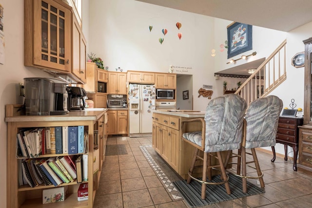 17159 Stalker Lake Rd, Battle Lake, MN 56515 - kitchen with stainless steel microwave, white refrigerator with ice dispenser, a towering ceiling, light brown cabinetry, and a center island