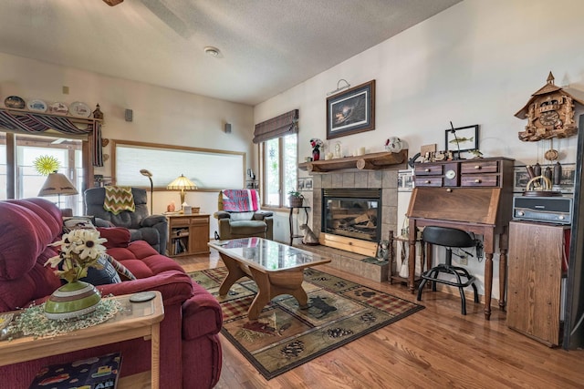 17159 Stalker Lake Rd, Battle Lake, MN 56515 - living room featuring wood finished floors, a tiled fireplace, and a textured ceiling