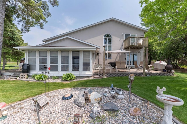 17159 Stalker Lake Rd, Battle Lake, MN 56515 - rear view of property featuring a patio area, a lawn, a balcony, stucco siding, and a sunroom
