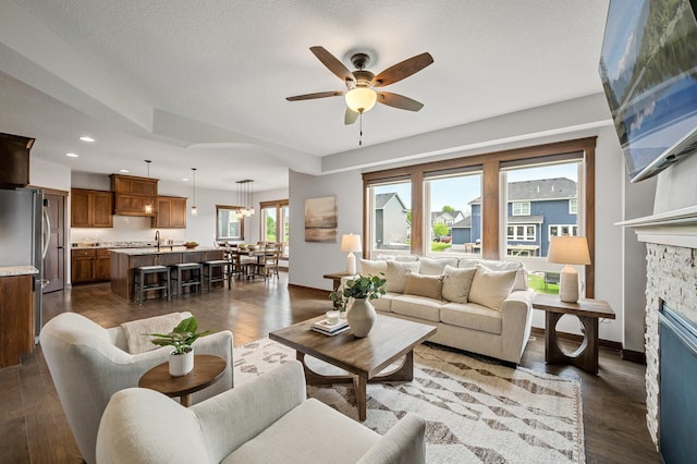 1840 Old Mill Ct, Centerville, MN 55038 - living room featuring a ceiling fan, a fireplace, baseboards, dark wood-type flooring, and recessed lighting