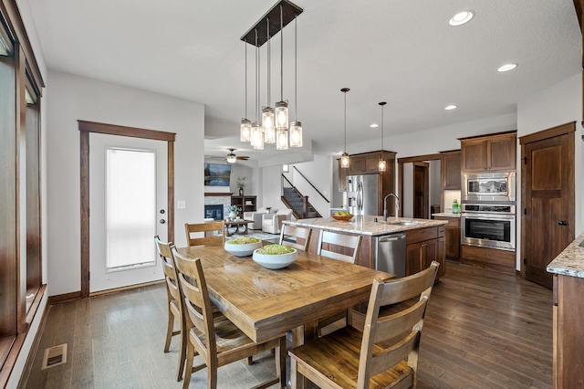 1840 Old Mill Ct, Centerville, MN 55038 - dining area with ceiling fan, a glass covered fireplace, dark wood-type flooring, recessed lighting, and stairway