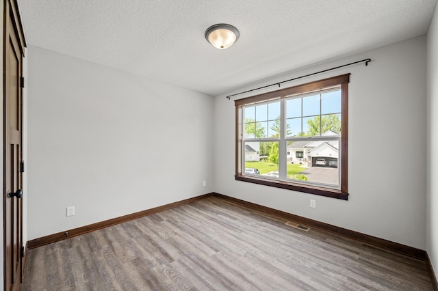 1840 Old Mill Ct, Centerville, MN 55038 - unfurnished room with wood finished floors, baseboards, and a textured ceiling