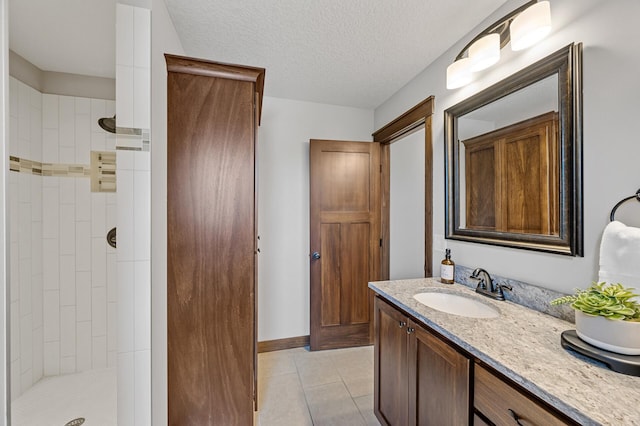 1840 Old Mill Ct, Centerville, MN 55038 - bathroom featuring vanity, tile patterned floors, tiled shower, and a textured ceiling