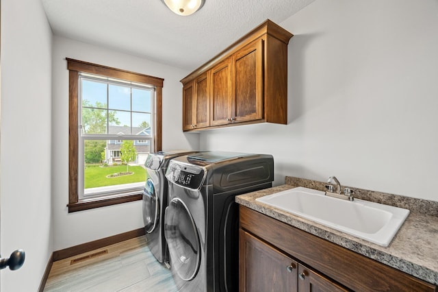 1840 Old Mill Ct, Centerville, MN 55038 - laundry area featuring washer and clothes dryer, cabinet space, baseboards, and a textured ceiling