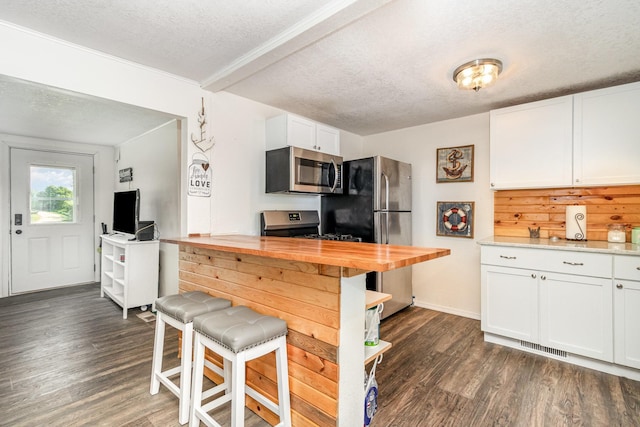 6269 85th St NW, Corinna Twp, MN 55358 - kitchen featuring appliances with stainless steel finishes, a textured ceiling, wooden counters, dark wood-style flooring, and white cabinetry