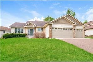 6426 84th St NE, Monticello, MN 55362 - view of front facade with driveway, an attached garage, and a front yard