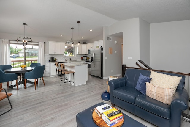 3900 Orchardview Ln NW, Rochester, MN 55901 - living area with lofted ceiling, light wood-style flooring, recessed lighting, baseboards, and a chandelier