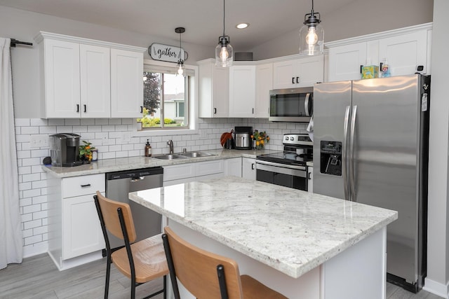 3900 Orchardview Ln NW, Rochester, MN 55901 - kitchen with appliances with stainless steel finishes, a sink, white cabinetry, decorative backsplash, and a kitchen breakfast bar