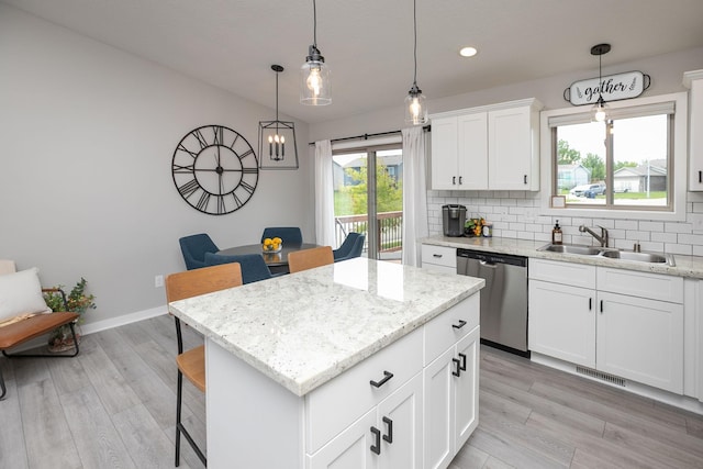 3900 Orchardview Ln NW, Rochester, MN 55901 - kitchen with dishwasher, a sink, a kitchen island, decorative backsplash, and light wood-style flooring