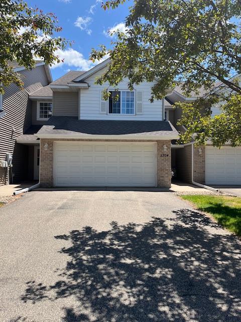 1704 Talon Trl, Eagan, MN 55122 - traditional-style house featuring brick siding, an attached garage, and driveway