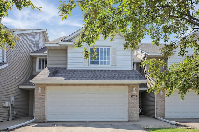 1704 Talon Trl, Eagan, MN 55122 - traditional-style house featuring roof with shingles, brick siding, and driveway