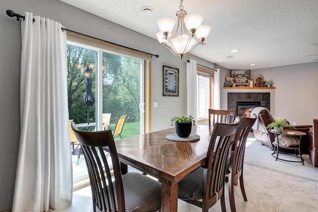 1704 Talon Trl, Eagan, MN 55122 - dining space with a textured ceiling, a chandelier, a tile fireplace, and light tile patterned floors