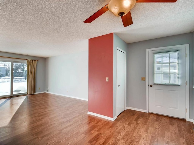 1029 Pond View Ct, Vadnais Heights, MN 55127 - unfurnished living room featuring a textured ceiling, wood finished floors, baseboards, and ceiling fan