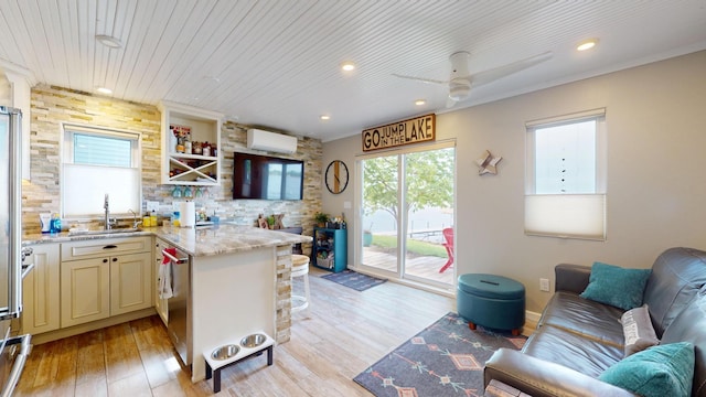 27096 Little Floyd Lake Rd Unit 2, Detroit Twp, MN 56501 - kitchen featuring a sink, an AC wall unit, a ceiling fan, light wood-style flooring, and light stone counters