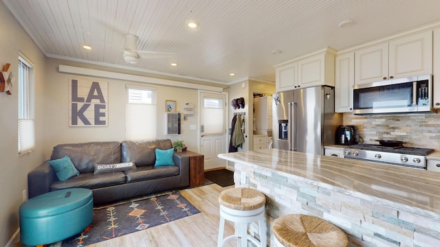 27096 Little Floyd Lake Rd Unit 2, Detroit Twp, MN 56501 - kitchen featuring appliances with stainless steel finishes, light wood-type flooring, a breakfast bar, open floor plan, and decorative backsplash