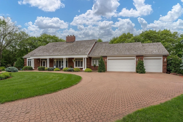 17 Oriole Pl, North Mankato, MN 56003 - ranch-style house with brick siding, decorative driveway, a front lawn, an attached garage, and a chimney