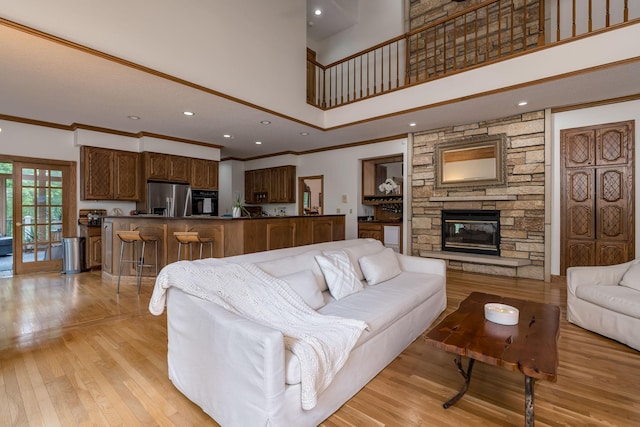 17 Oriole Pl, North Mankato, MN 56003 - living room with a towering ceiling, light wood-style flooring, crown molding, a fireplace, and recessed lighting