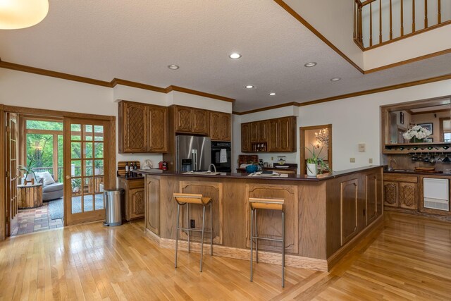 17 Oriole Pl, North Mankato, MN 56003 - kitchen featuring stainless steel refrigerator with ice dispenser, oven, dark countertops, light wood finished floors, and a sink