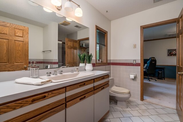 17 Oriole Pl, North Mankato, MN 56003 - bathroom with tile patterned flooring, vanity, toilet, tile walls, and a wainscoted wall