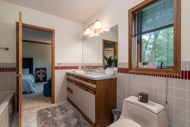17 Oriole Pl, North Mankato, MN 56003 - ensuite bathroom featuring tile walls, wainscoting, tile patterned flooring, vanity, and a tub