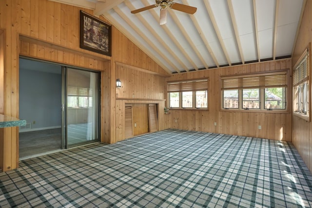 1158 Rockstone Ln, New Brighton, MN 55112 - unfurnished living room featuring vaulted ceiling, wood walls, healthy amount of natural light, carpet, and a ceiling fan