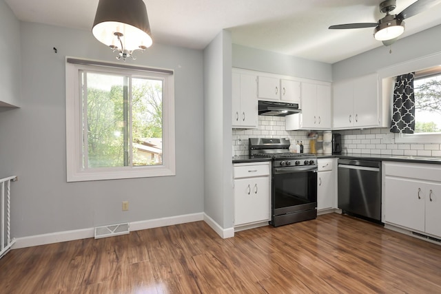 1158 Rockstone Ln, New Brighton, MN 55112 - kitchen featuring stainless steel appliances, dark countertops, under cabinet range hood, backsplash, and dark wood finished floors